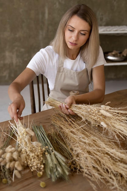 Woman building her own dried flowers arrangement