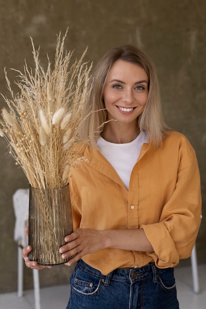 Foto gratuita donna che costruisce la propria composizione di fiori secchi