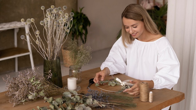 Woman building her own dried flowers arrangement