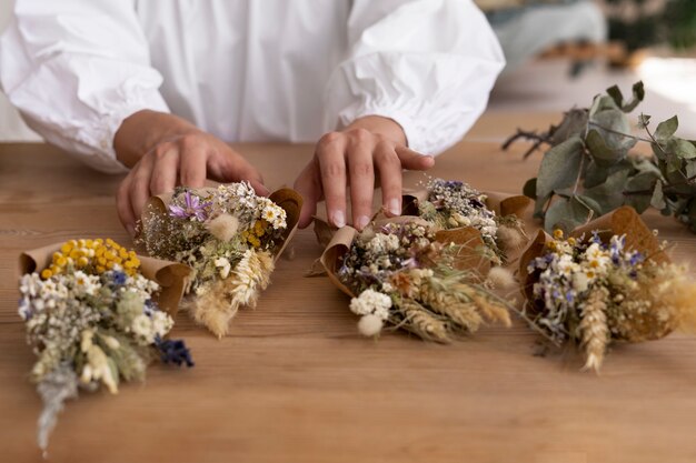 Donna che costruisce la propria composizione di fiori secchi