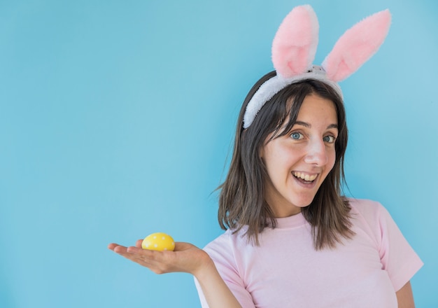 Woman in bunny ears holding Easter egg