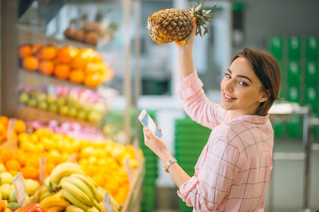 Женщина покупает в продуктовом магазине