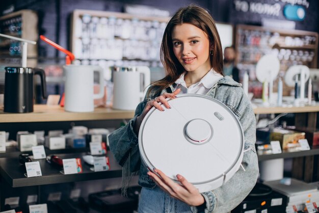 Free photo woman buying wireless vacuum cleaner at store