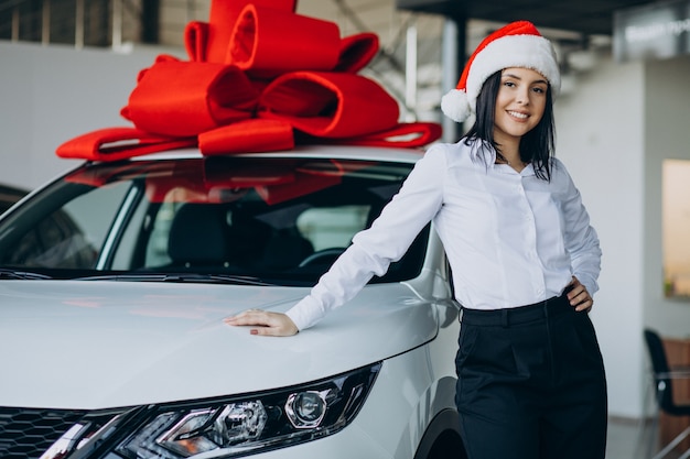 Woman by the car with red bow