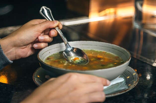 A woman in a cafe eats a lowcalorie vegetable soup