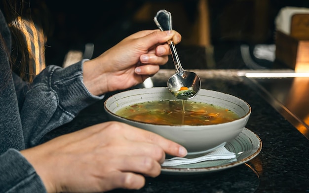 Foto gratuita una donna in un caffè mangia una zuppa di verdure a basso contenuto calorico