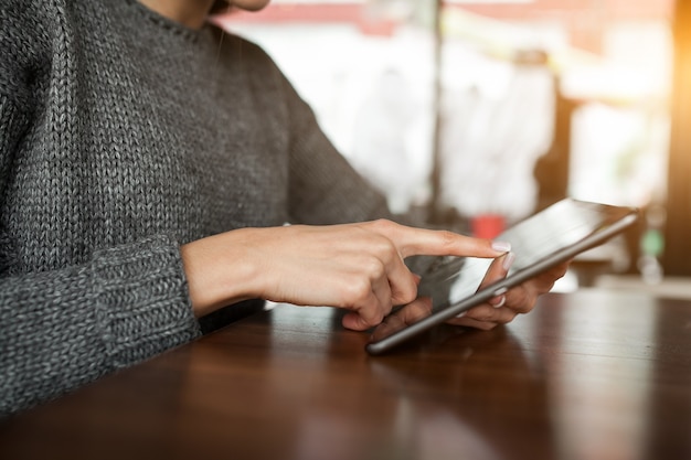 タブレットモバイルを使用した女性のカフェ