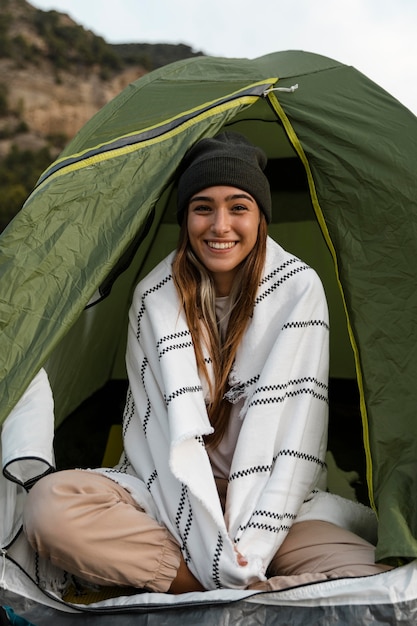 Woman camping and sitting in tent