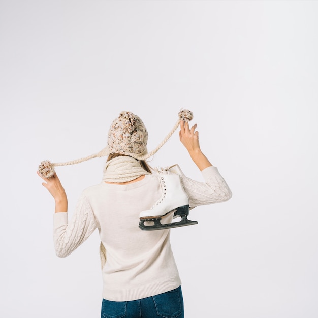 Woman in cap holding skates