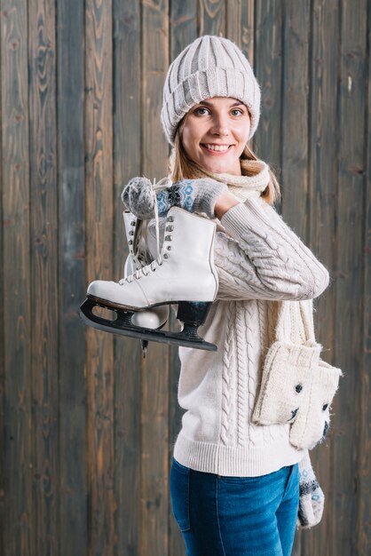 Woman in cap with skates behind back