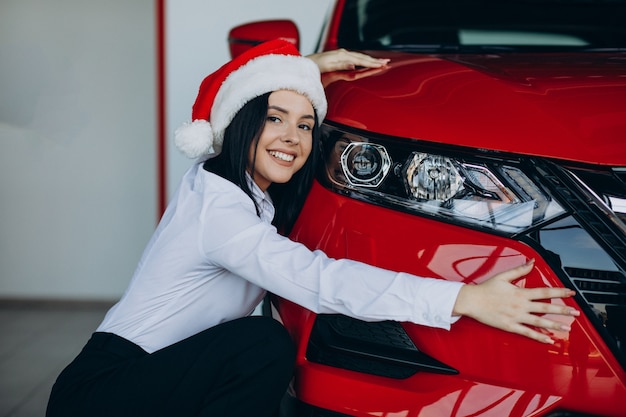 Free photo woman in a car showroom on christmas