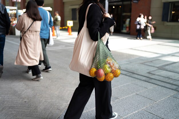 Женщина с сумкой с фруктами, вид сбоку