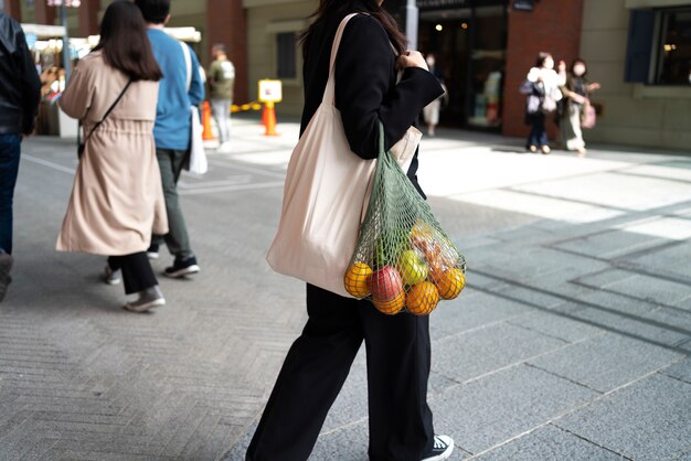 Woman carrying bag with fruits side view