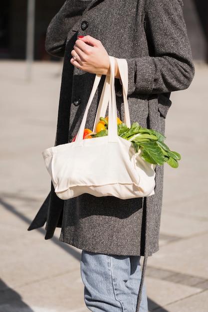 Free photo woman carrying bag with organic vegetables