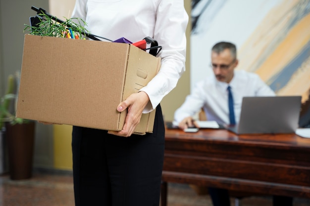 Woman carrying cardboard box side view