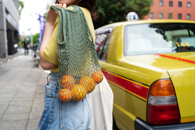 Woman carrying fabric bags side view