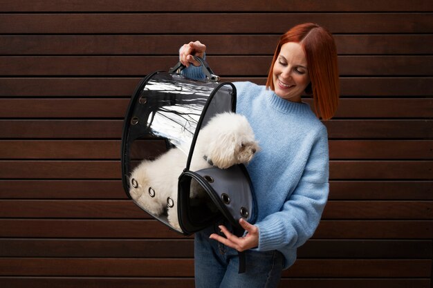 Foto gratuita donna che porta il suo cane in una speciale borsa da trasporto