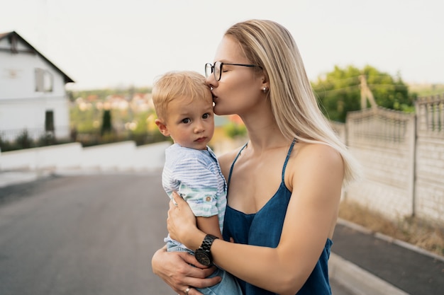 息子を背負って額にキスをする女性。