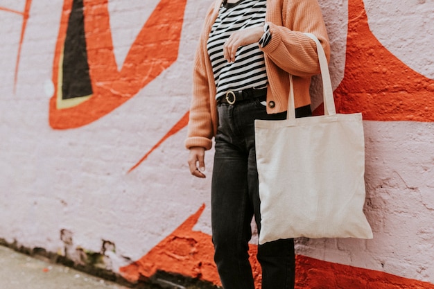 再利用可能な空白のキャンバストートバッグを運ぶ女性 Premium写真