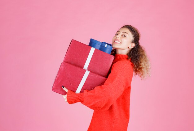 woman carrying a stock of big gift boxes.