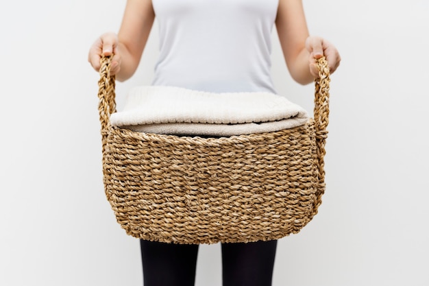 Free photo woman carrying weaved laundry basket lifestyle concept
