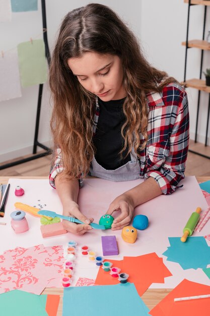 Woman carving colorful clay for making cartoon face