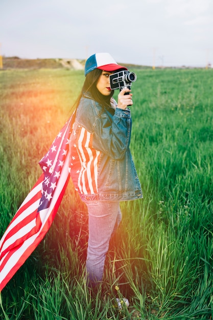 Woman in casual clothes staying with retro camera