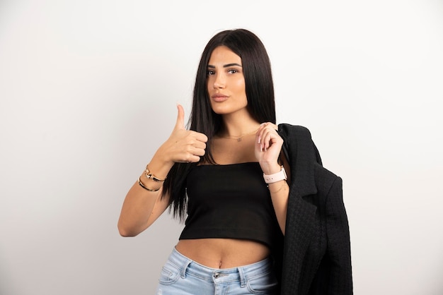 Woman in casual outfit making thumbs up sign. High quality photo