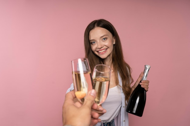 Woman celebrating with champagne bottle and glasses