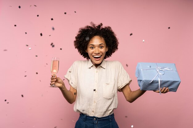 Woman celebrating with champagne glass and present