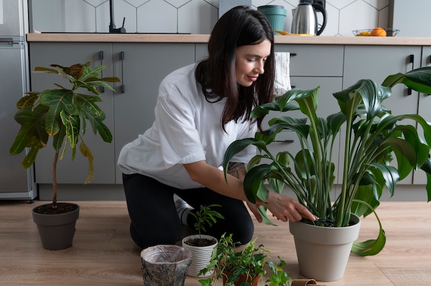 검역 중에 집에서 식물의 화분을 바꾸는 여자