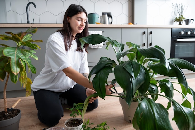検疫中に自宅で植物の鉢を変える女性