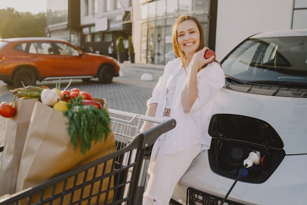 Woman charging electro car at the electric gas station