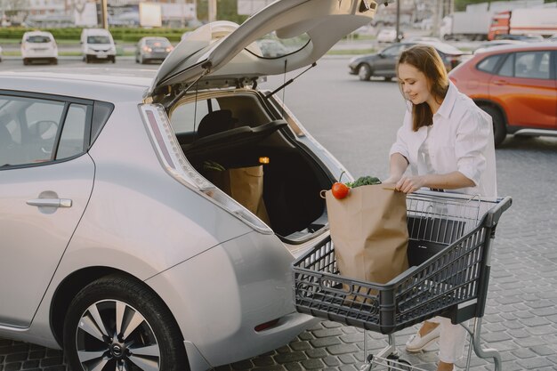 Woman charging electro car at the electric gas station