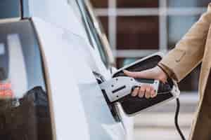 Free photo woman charging electro car at the electric gas station