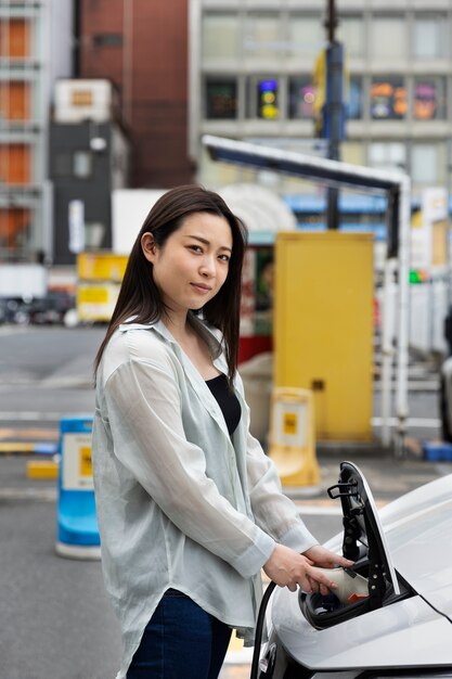 Woman charging her electric car at the station