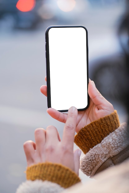 無料写真 空の画面のスマートフォンをチェックする女性