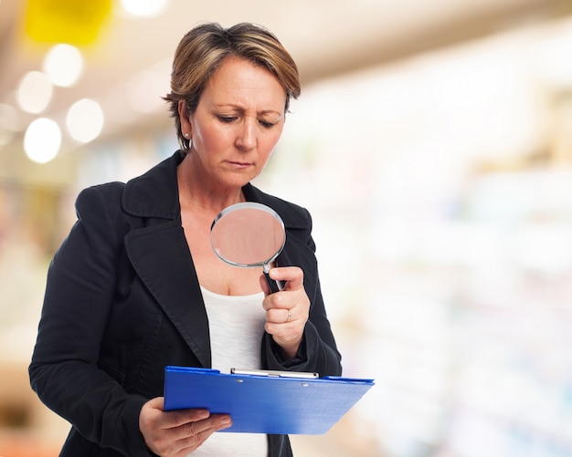 Woman checking a folder with a magnifying glass