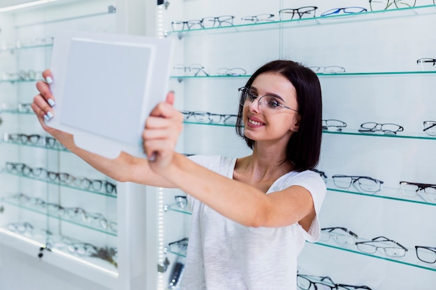 Woman checking frame in mirror