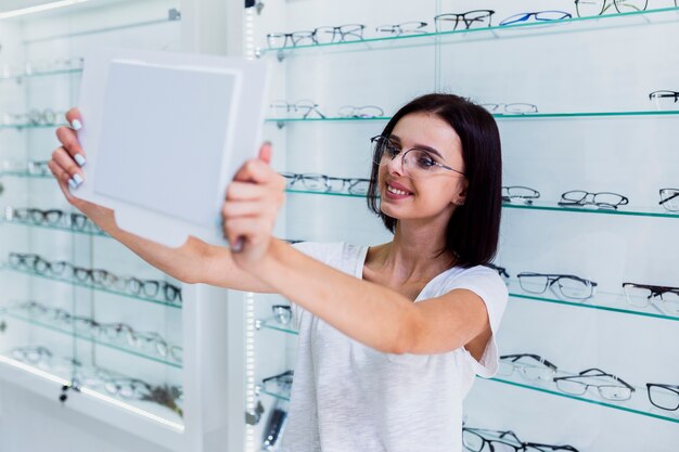 Woman checking frame in mirror