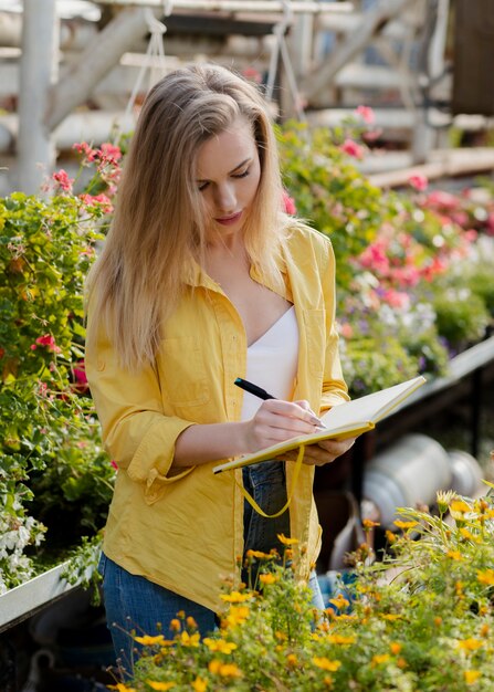 Woman checking greenhouse agenda needs