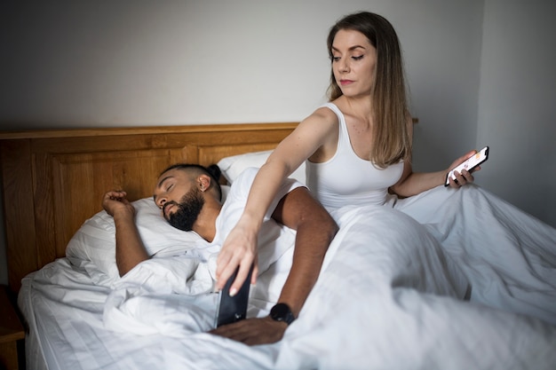 Женщина проверяет телефон своего парня во время сна