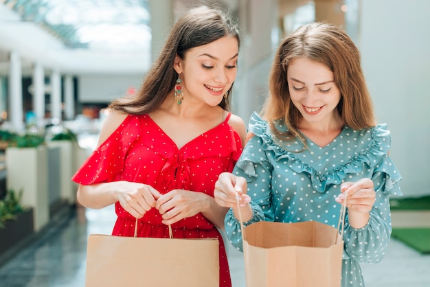 彼女の友人の買い物袋をチェックする女性