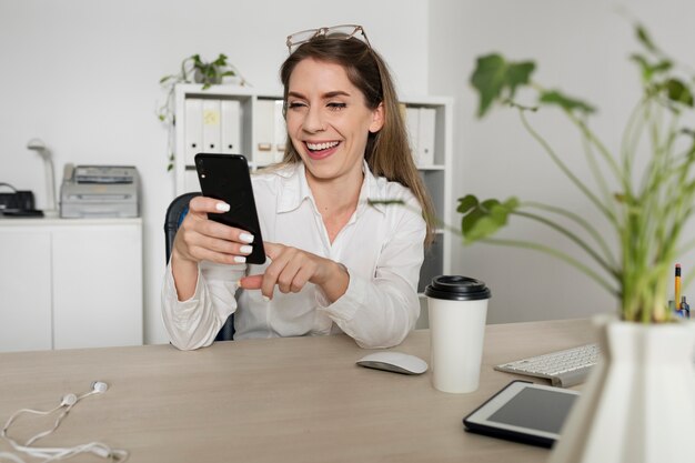 Woman checking her smartphone at work