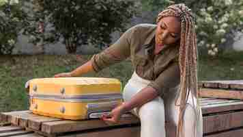 Free photo woman checking her yellow luggage