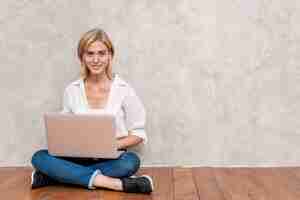 Free photo woman checking laptop with copy space