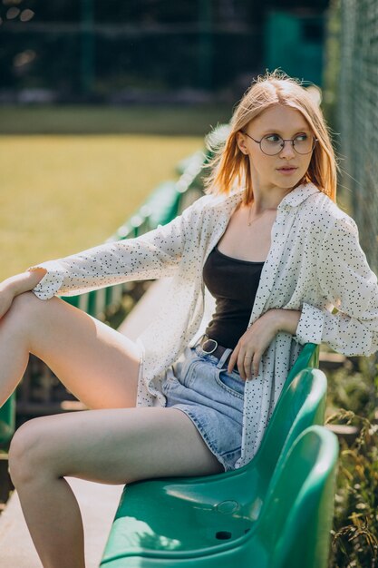 Woman cheerleader sitting at the football field