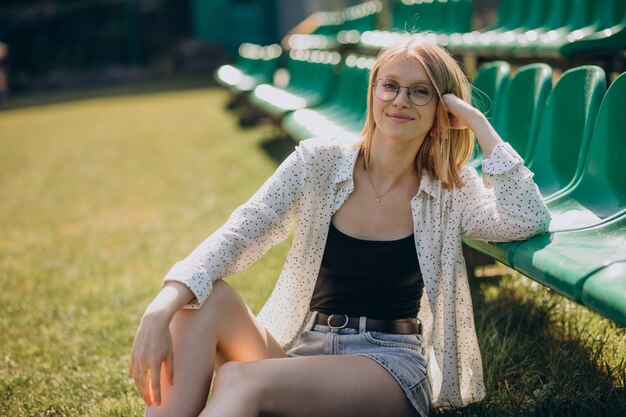 Woman cheerleader sitting at the football field