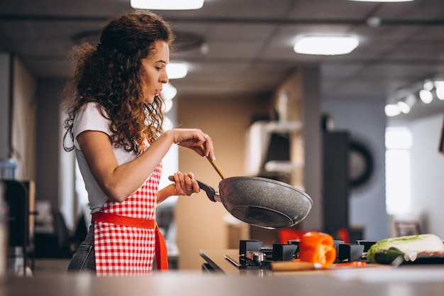 Woman chef cooking vegetables in pan