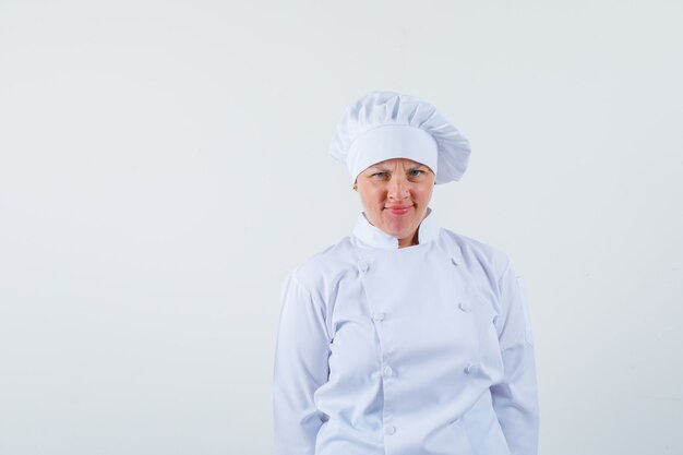 woman chef looking at front in white uniform and looking displeased.